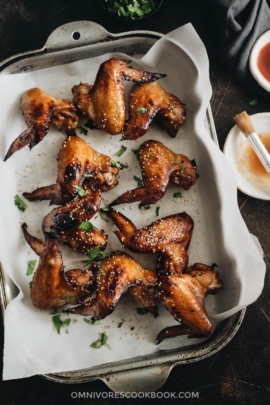 Baked honey soy chicken wings on parchment lined baking sheet