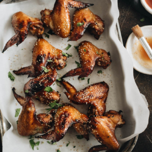 Baked honey soy chicken wings on parchment lined baking sheet