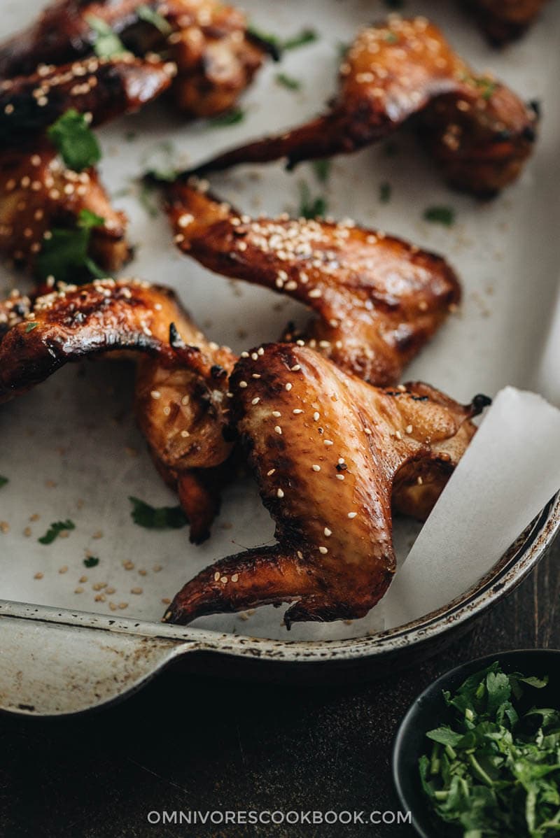 Close-up of baked honey soy chicken wings on parchment-lined baking sheet