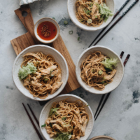 Chinese chicken noodle salad served in small bowls with chili oil on the side