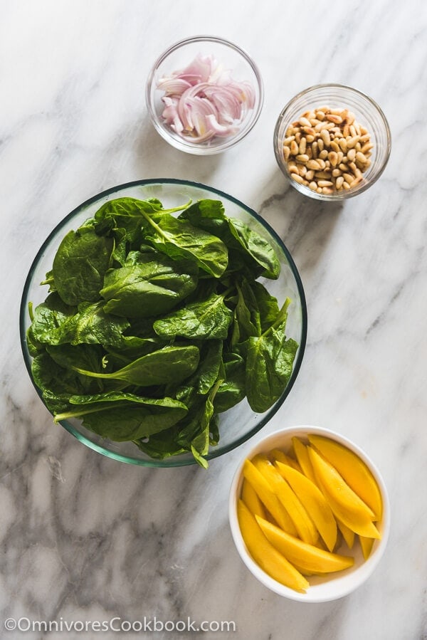The spinach salad is served with a refreshing sweet and sour vinaigrette with sweet mango slices and toasted pine nuts. It takes no time to put together and adds a delicious green to your main dish!