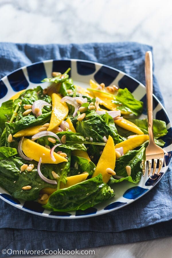 The spinach salad is served with a refreshing sweet and sour vinaigrette with sweet mango slices and toasted pine nuts. It takes no time to put together and adds a delicious green to your main dish!