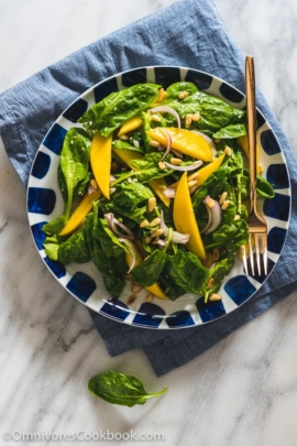 The spinach salad is served with a refreshing sweet and sour vinaigrette with sweet mango slices and toasted pine nuts. It takes no time to put together and adds a delicious green to your main dish!