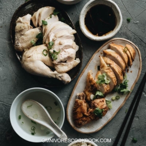 Homemade Hainanese Chicken Rice two ways - the original and the soy sauce version, served with rice, soup, and a salad.