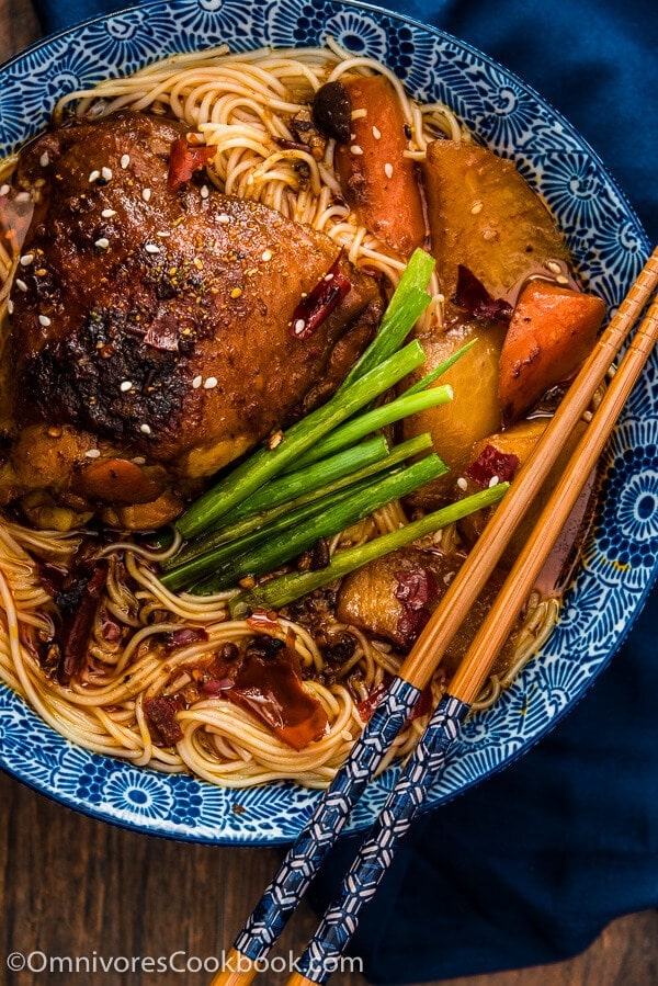 These spicy chicken noodles feature a super rich broth with juicy chicken. Learn to use the steam braising skill to cook a very flavorful chicken in much less time! | omnivorescookbook.com