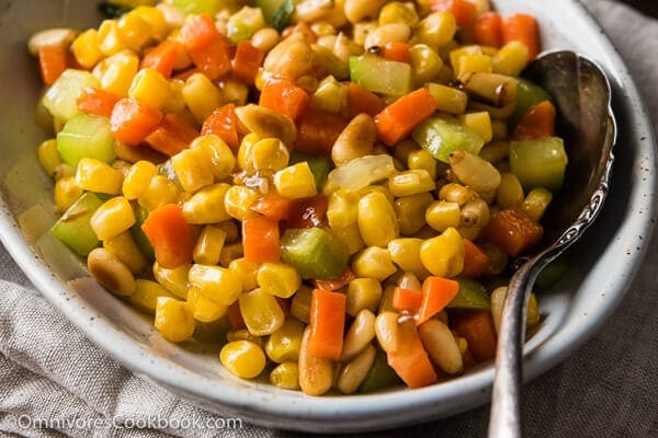 Stir Fried Corn with Pine Nuts (松仁玉米) - The sweet corn kernels, pine nuts, cucumber, and carrot are lightly seasoned with green onion, salt, and sugar. Every ingredient comes together to create a hearty meal that is nutty and sweet | omnivorescookbook.com