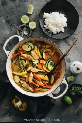 Vegetarian Thai curry in dutch oven with a plate of rice on the side