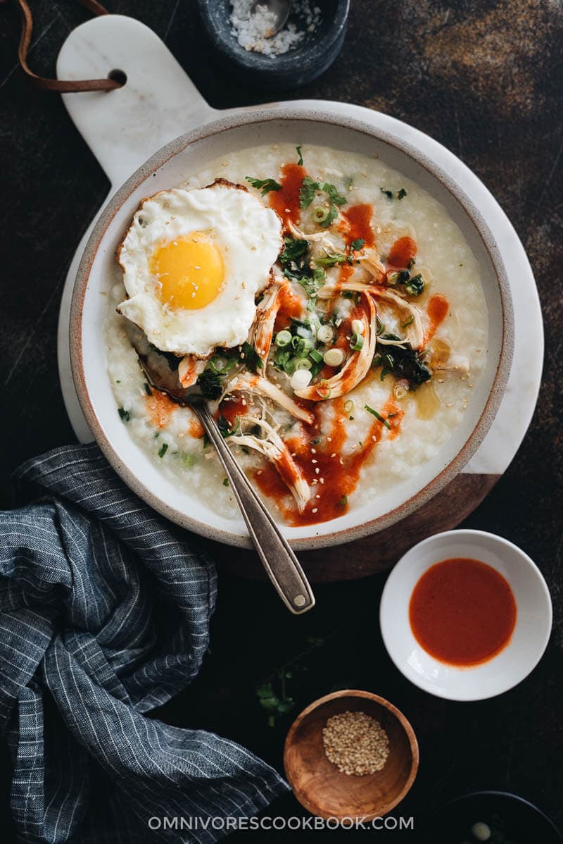 Close up of Instant Pot congee with chicken and spinach topped with egg served in a bowl