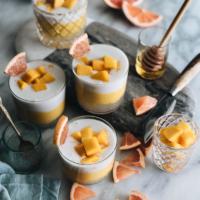 Four cups of mango sago served with grapefruits as a garnish