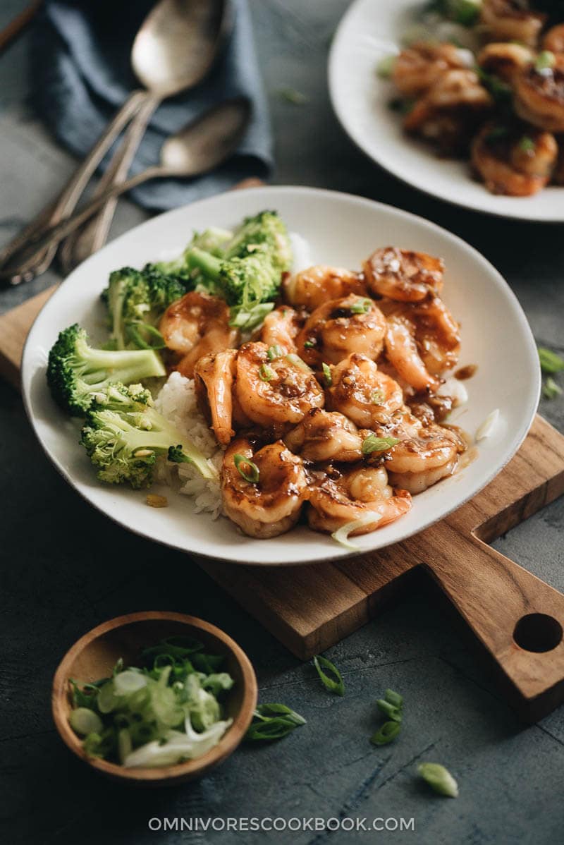 A plate of honey garlic shrimp served with steamed rice and broccoli
