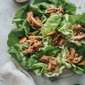 Instant pot shredded chicken lettuce wrap with Sriracha sauce and green onion on the side
