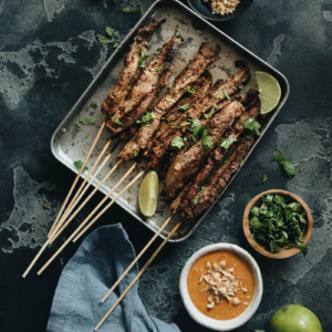 Beef satay served with peanut sauce and cilantro