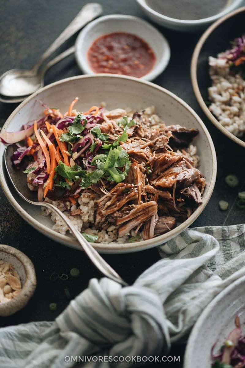 Asian Instant Pot pulled pork served on steamed brown rice and coleslaw closeup