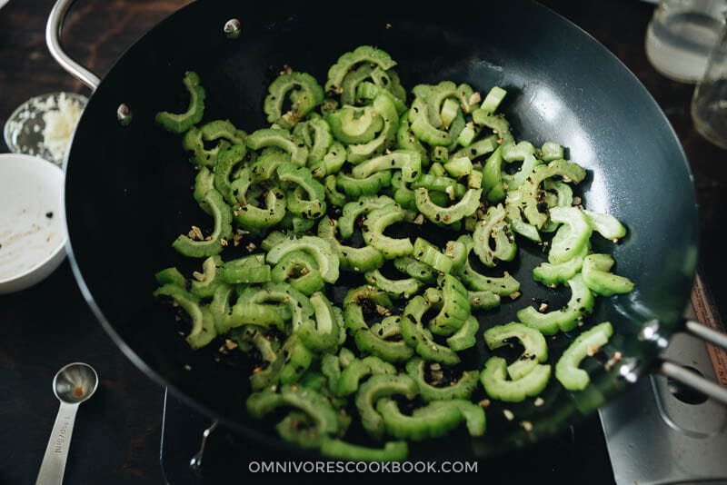 Cooking stir fried bitter melon in a wok