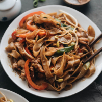 15-Minute Chicken Chow fun - This chicken fried noodle recipe is super fast to make and yields restaurant-style results. The dish is loaded with fat rice noodles, tender chicken, and crisp veggies. No wok required! #recipe #comfortfood #stirfry #glutenfree