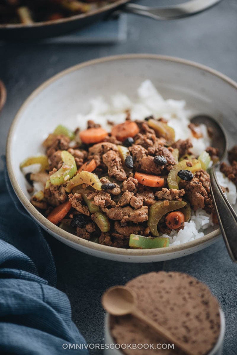 Ground beef stir fry with celery served over steamed rice close up
