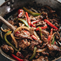 Easy Szechuan Beef Stir Fry - Tender crispy beef cooked in a bold sweet sour spicy sauce with peppers and onions. Learn how to make the richest sauce and create crispy beef without deep-frying. {Gluten-free adaptable}