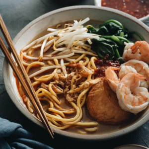 Hokkien Prawn Mee Noodle Soup (Hae Mee) - Tender yellow noodles in a rich savory-sweet red-orange broth served with juicy prawns, fish cakes, crunchy bean sprouts, and crispy fried shallots. {Gluten-Free adaptable}