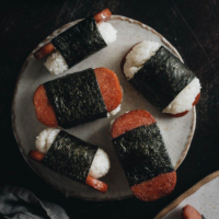 Spam Musubi - The spam is grilled until crispy, perfectly caramelized with soy sauce and sugar, and wrapped with sushi rice. Made ahead of time, these Spam musubi are perfect for your lunchbox, appetizer platter, or potluck. They are also a fantastic game-day snack. This recipe uses just the right amount of seasoning to create a balanced flavor that’s addictively tasty.