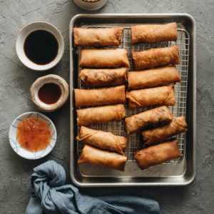 Fried Chinese egg rolls on cooling rack