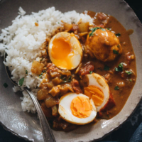 Easy Egg Curry - Tender eggs are smothered in a super rich curry sauce with a tomato and coconut base. The recipe shows you how to cook a tasty curry using minimal ingredients, making it a perfect dish for a busy weekday dinner. {Gluten-Free}