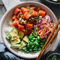 Salmon poke bowl - a perfect one-bowl meal that’s easy to make and packed with nutrition. The recipe uses an extra aromatic sauce that has the right balance of savory, sour, sweet, and spicy. The dish is quick enough to make for a weekday dinner and fancy enough to serve at your weekend dinner party. {Gluten-free adaptable}