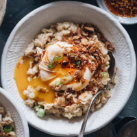 Avena salada de 5 ingredientes (estilo chino) | Esta avena se cocina a fuego lento con caldo de pollo hasta que esté cremosa, se cubre con huevos líquidos, se sazona con salsa de soja y aceite de chile, y se termina con chalotas fritas crujientes. Este plato de desayuno es muy fácil de preparar y la combinación crea un sabor atrevido con una hermosa textura. {Sin gluten}