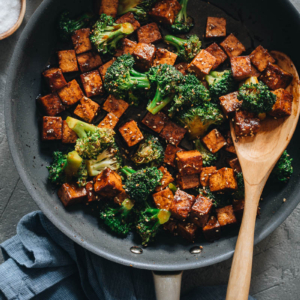 Tofu with broccoli in brown sauce in frying pan
