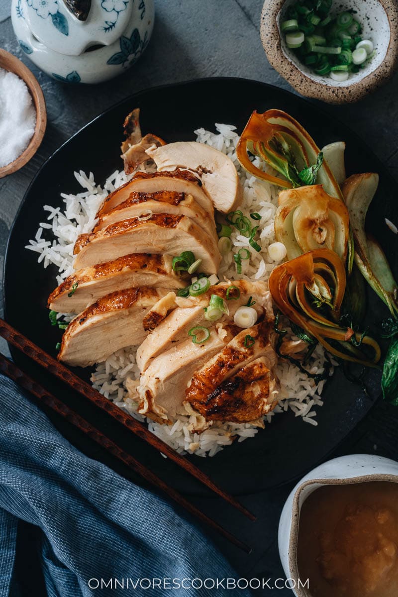 Carved roast chicken served on rice with baby bok choy