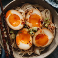 Marinated eggs on noodles with chili oil close-up