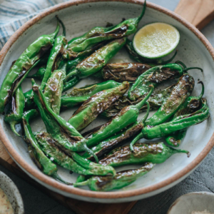 Charred shishito peppers in a bowl