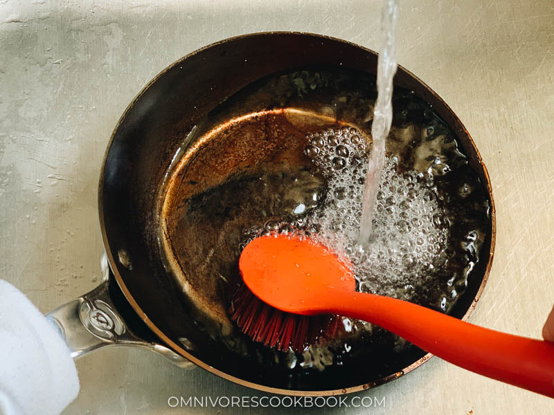 Wash carbon steel pan with wok brush