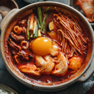 Take your taste buds to Korea with sundubu-jjigae, a delightfully spicy tofu stew that will bring you comfort and warmth in every bowl!