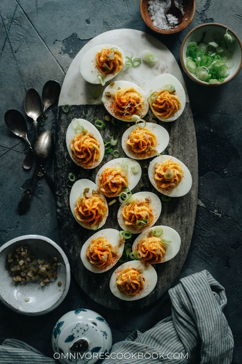 Deviled eggs garnished with chili flakes and green onions