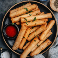 Lumpia Shanghai is a perfect appetizer and finger food for parties and festive dinners. These super crispy and crunchy egg rolls are packed with pork, carrots, celery, and onions and come with a sweet yet spicy dipping sauce that will have everyone sopping up every last morsel!