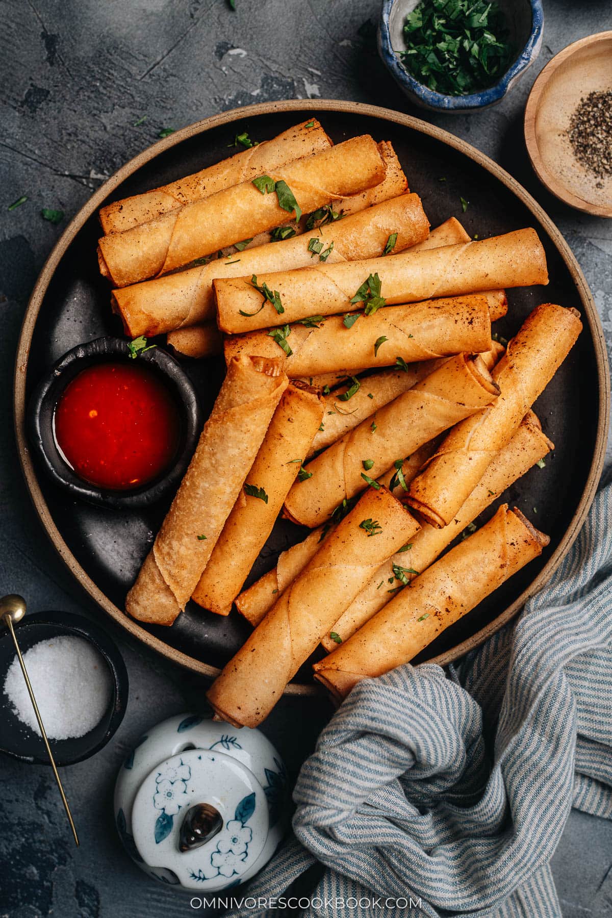 Crispy Lumpia Shanghai served with sweet chili sauce on a plate.
