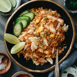 Crab fried rice with lime wedges and cucumber