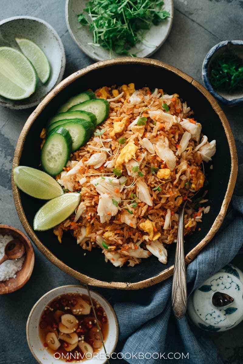 Crab rice with lime wedges and cucumber