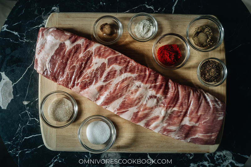 A raw rack of pork ribs with spices for rubbing