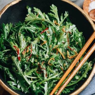 Chrysanthemum greens in a bowl with Asian dressing