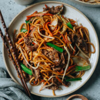 felii de carne de vită amestecate cu tăiței groși lo mein, legume și un sos savuros sunt perfecte pentru cina din această seară în această carne de vită Lo mein. Și este nevoie de mai puțin timp decât takeout pentru a pune pe masa ta!