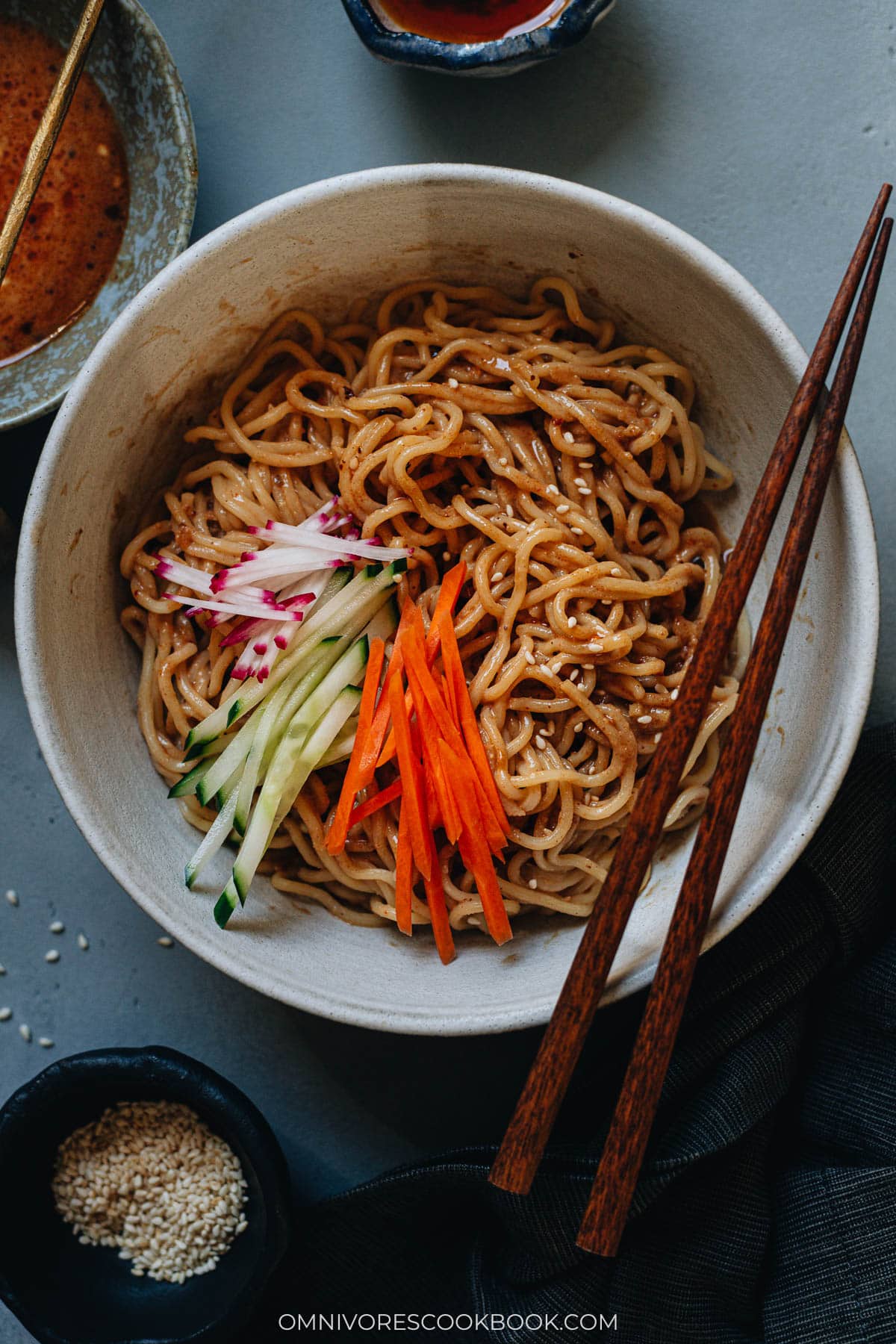 Chinese sesame noodles in a bowl with cucumber and radish