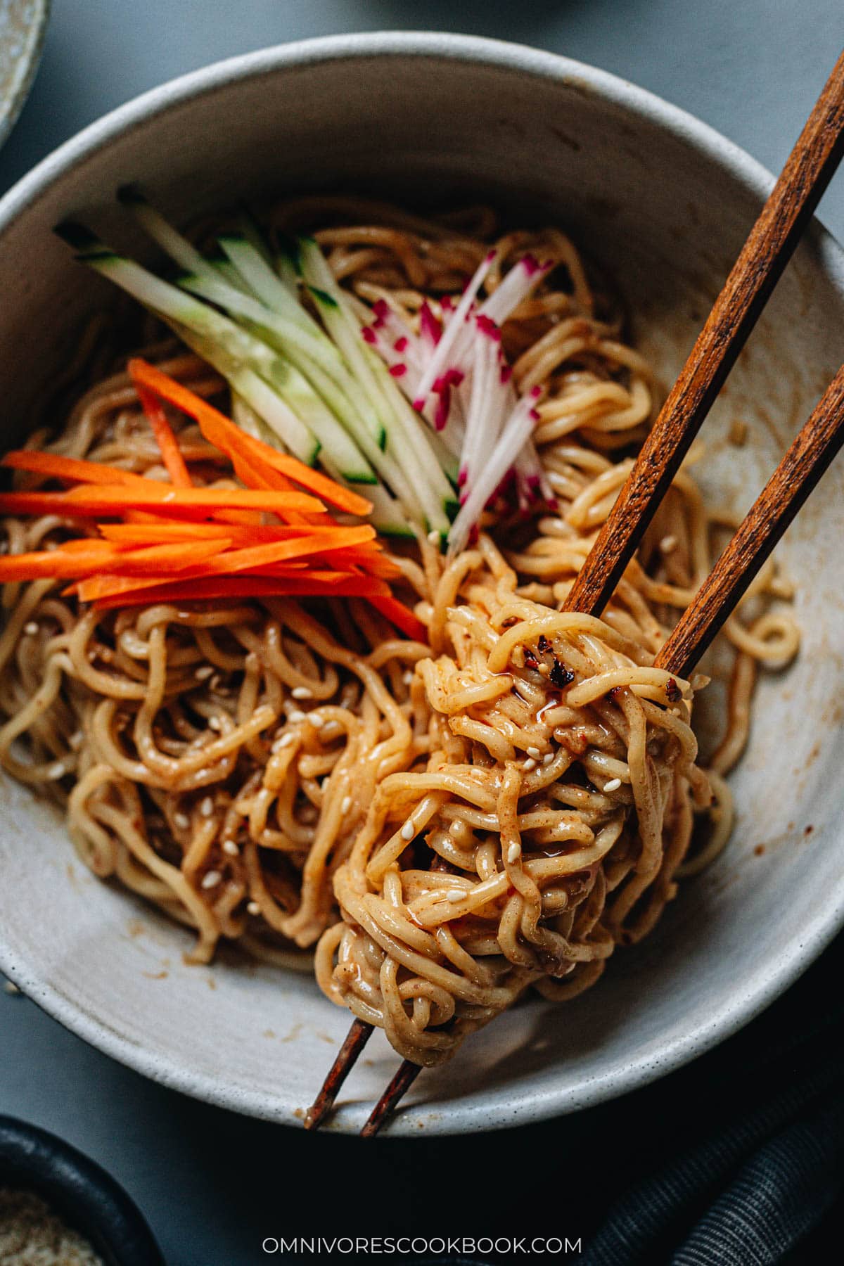 Chinese noodles in a bowl with sesame sauce and vegetables