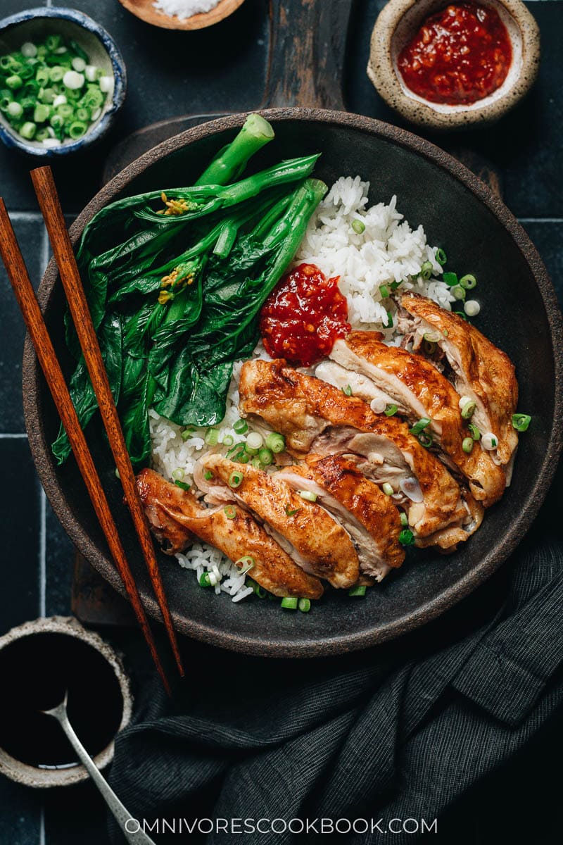Carved skin-on chicken over rice with Chinese broccoli
