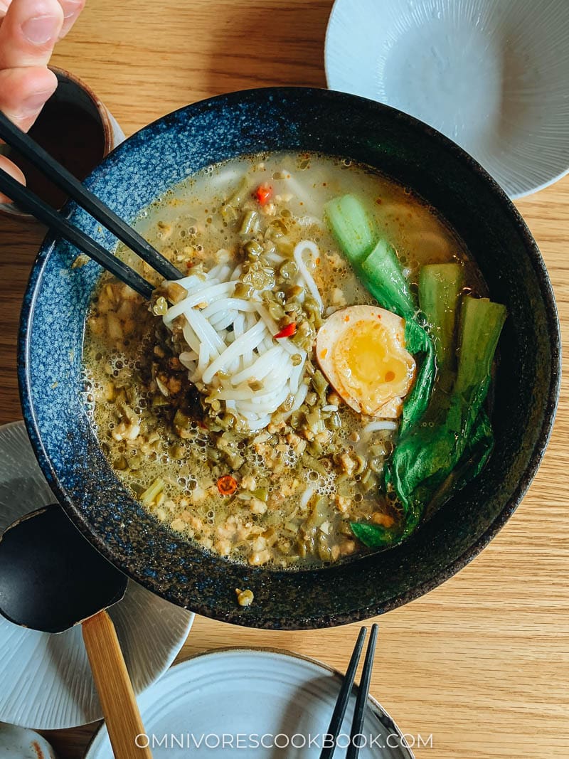 Rice noodle soup with pickled string bean, pork, and runny egg