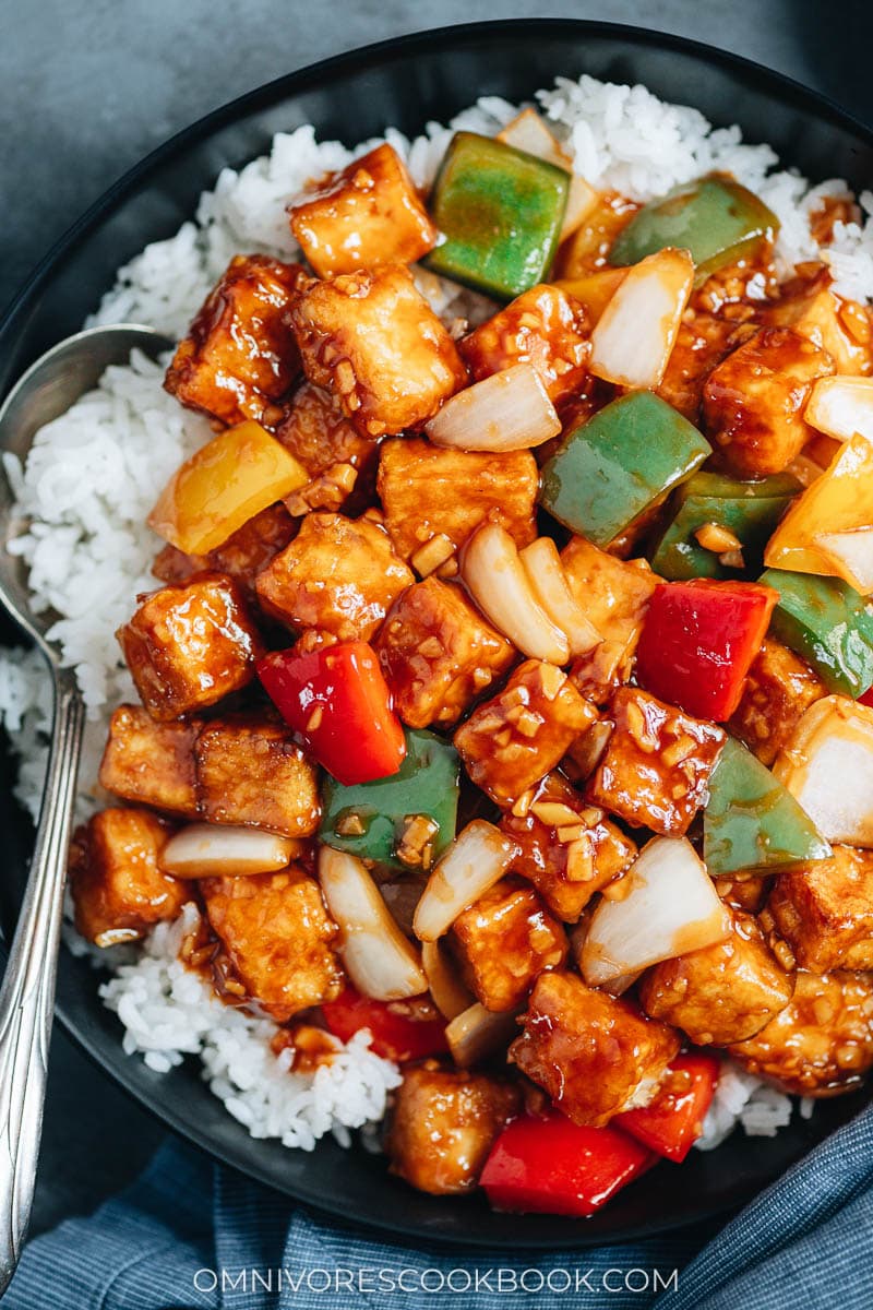 Sweet and sour tofu over steamed rice close up