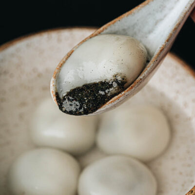 Black sesame tang yuan close up with filling oozing out