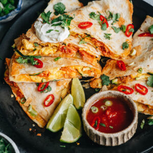 Egg and kimchi quesadilla served with lime, sour cream and salsa