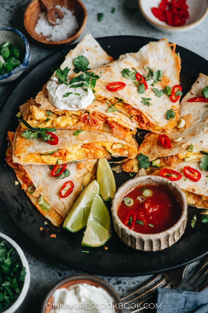 Egg and kimchi quesadilla served with lime, sour cream and salsa