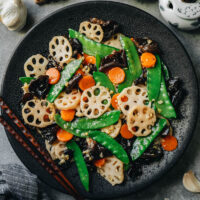 Stir fried lotus root, carrot, snow peas and wood ear mushrooms are tossed in a light savory sauce with a lot of garlic and ginger. It’s a dish that celebrates the spring. It’s super quick and easy to put together, making it the perfect side dish for your dinner. {Vegan, Gluten-Free Adaptable}